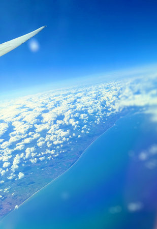 Aerial view of blue sky with white clouds and airplane wing.の写真素材
