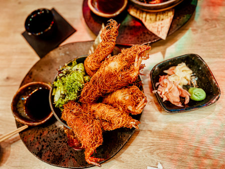 Thai style fried chicken with spicy sauce on wooden table in restaurantの写真素材