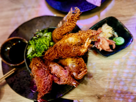 Thai style fried chicken with spicy sauce on wooden table in restaurantの写真素材