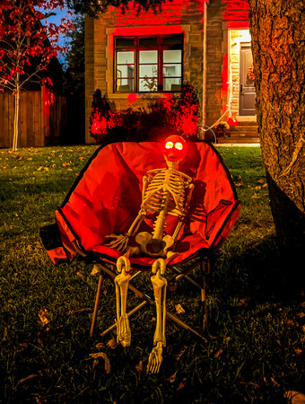 Scarecrow in the garden at night with garlands and lights. Halloween concept. Selective focus.の写真素材