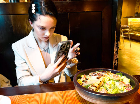 Beautiful brunette woman in a restaurant with a mobile phone.