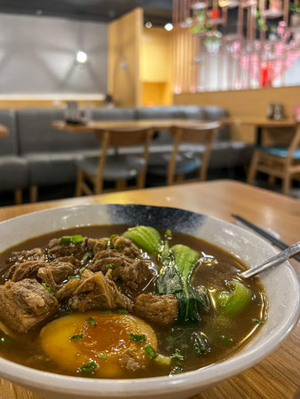 Beef noodle soup with pork and egg in a restaurant.