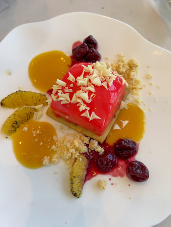 Dessert with fruit and berries on a white plate in a restaurantの写真素材