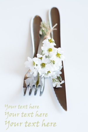 Fork, knife and a small bouquet of white flowersの写真素材