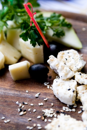 Splitting a solid tasty goat cheese with sesame seeds and herbsの写真素材