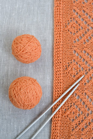 Orange balls, knitted pattern and knitting needles