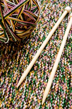 Great ball of colored yarn, wooden knitting needles and knit fabric の写真素材