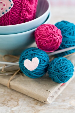 Bright balls of yarn in blue plates and heart made   8203;  8203;of feltの写真素材