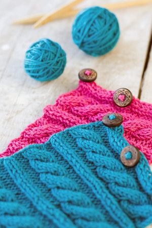 Knitting pattern and button on a wooden background
