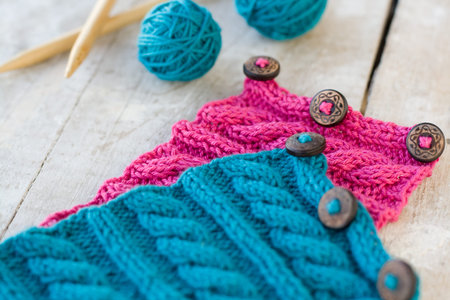 Knitting pattern and needles on a wooden background