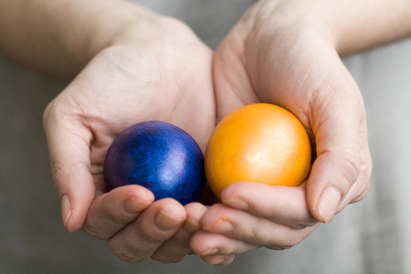 The girl holds in hands colored Easter eggsの写真素材