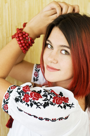 Beautiful Ukrainian girl in traditional embroidered shirt and green eyesの写真素材