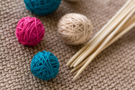 Colorful balls and wooden needles lying on beige