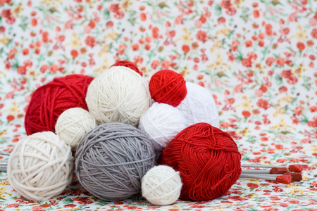 A lot of bright balls of knitting on the background of a red flowerの写真素材
