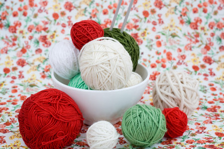 A lot of bright balls of knitting on the background of a red flower