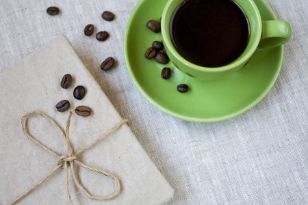 Green cup of coffee with coffee beans and vintage notebookの写真素材