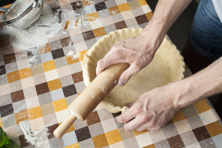 Cooking and home concept - close up of male hands kneading dough on a background in cellの写真素材