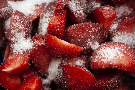A healthy and tasty snack: juicy strawberry slices covered in sugar.の写真素材