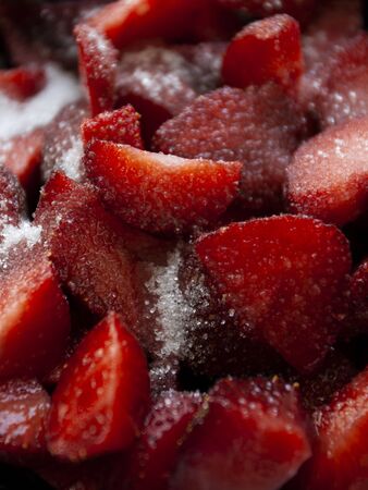 A healthy and tasty snack: juicy strawberry slices covered in sugar.の写真素材