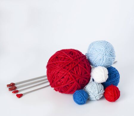 Bright knitting balls and metal knitting needles on a white background. There is a place for text nearby.の写真素材
