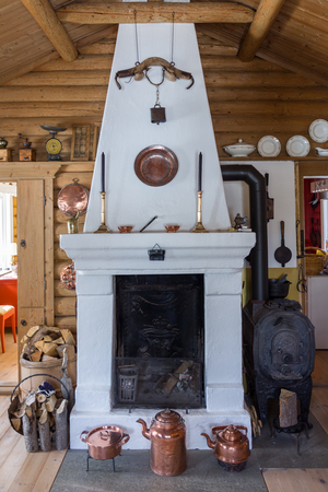 old fireplace in a wooden cottage with several antique objects,norwayのeditorial素材