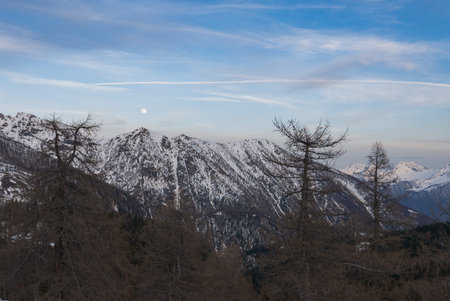 Snowy panorama of the Val Bognanco that opens behind Domodossola, in background the moon Piedmont,...