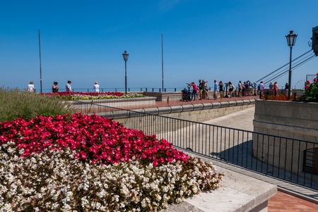 SAN MARINO, REPUBLIC OF SAN MARINO - 6 AUGUST 2018: Arrival of the San Marino cableway while tourists admire the spectacular view over the valleyのeditorial素材