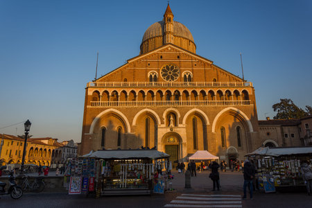 PADUA, ITALY - December 28, 2016 - Souvenir sellers and tourists in front of the Basilica of...