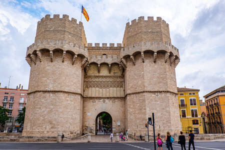 Valencia, Spain: June 13, 2015 - Tourists visit the Torre de Serranos with the Valencian flag blowing in the windのeditorial素材