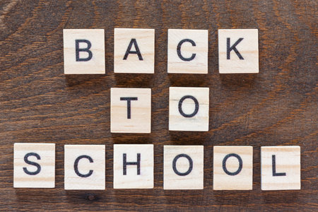 animation with lettering back to school with light wooden letters on dark wooden background, first...