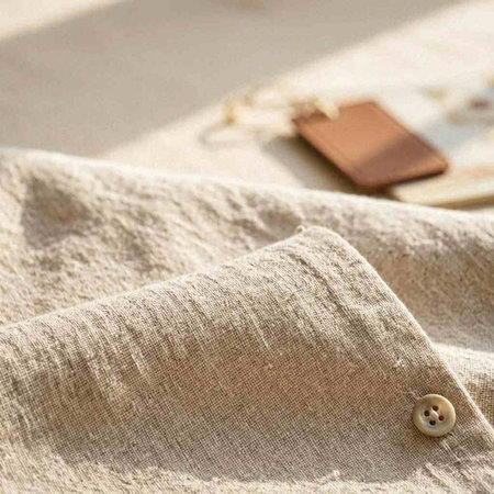 Closeup of a beige jacket with buttons and a blank card