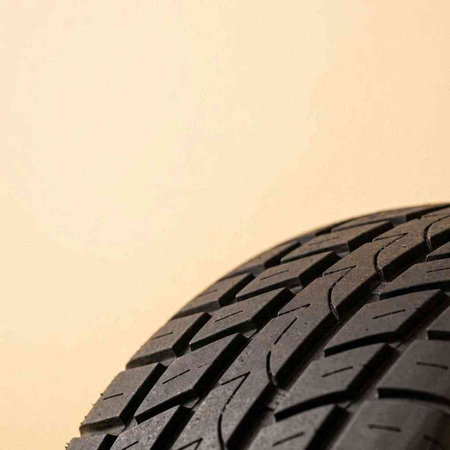 Car tire on a beige background with copy space for text.