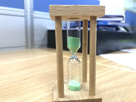 A three minutes Green color sand glass timer is active for an meeting time as a deadline for an task...