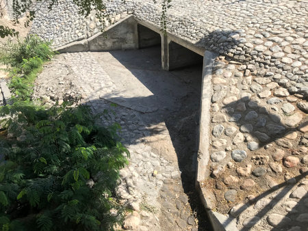 concrete box culvert with two channels with construction of apron head wall toe walls which are protected by rip rap stones for vehicle crossing storm water drainage purpose