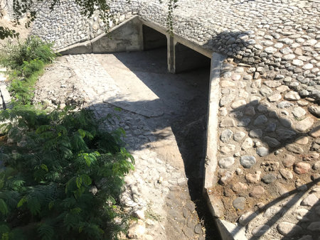 concrete box culvert with two channels with construction of apron head wall toe walls which are protected by rip rap stones for vehicle crossing storm water drainage purpose