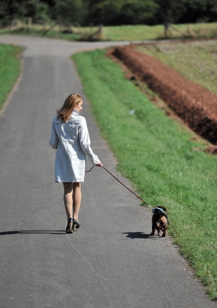 Young woman is walking with her small dog  の写真素材