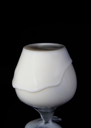 Splash milk in the glass on the black backgroundの写真素材