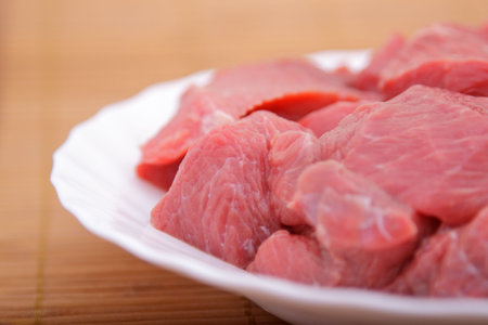 Red meat on white plate and bamboo napkin