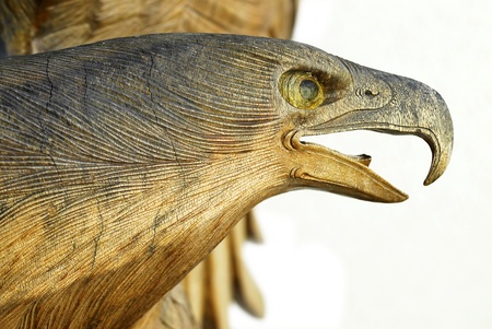 Head of an eagle carved in wood isolated on white backgroundの写真素材