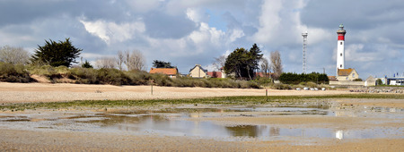 Panoramic photo of beach at low tide and lighthouse of Ouistreham , commune in the Calvados department in the Basse-Normandie region in northwestern France の写真素材