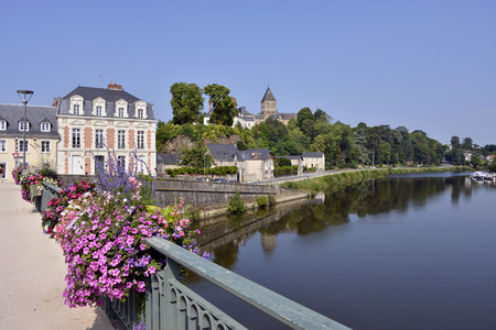 Port is Mayenne river at ChteauGontier SaintJeanBaptiste with the church in the common background in the department Mayenne Pays de la Loire Region in northwestern Franceの写真素材