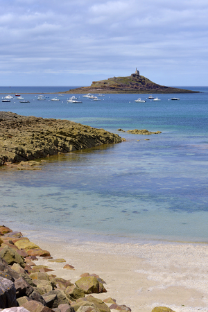 Beach and islet with the chapel St. Michael in the background at Erquy, near Port Hopitaux. Erquy is a commune in the C?tes-d'Armor department of Brittany in northwestern France on the coast of PenthiÃ¨vre.の写真素材