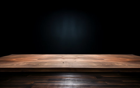 An empty wooden table for presentation with a dark background and isolated recessed lightingの素材
