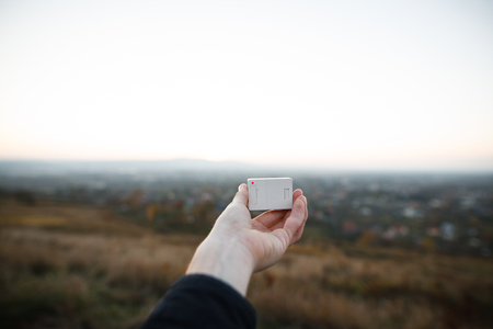 human hands holding an action camera on the sunset backgroundの写真素材