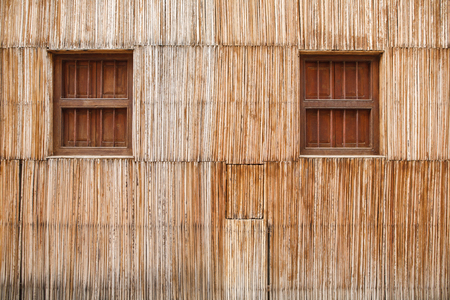 Wall of a thatched house with close windowsの写真素材