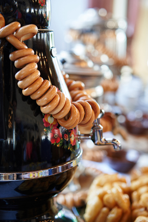 Russian traditional painted samovar with delicious herbal tea and delicious donutsの写真素材