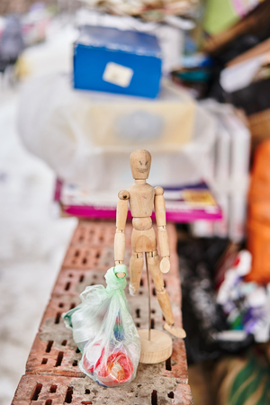Wooden toy and a trash bag in his handsの写真素材