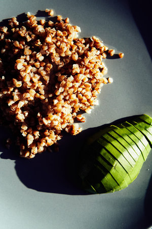Healthy breakfast with avocado and buckwheat porridge on a stylish plate.