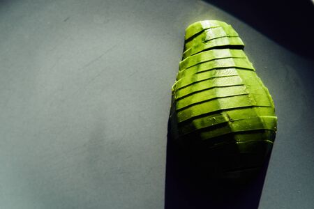 food background with fresh organic avocados on a plate, top view, copy space. Sliced Avocado Productの写真素材