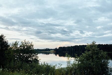 A large body of water surrounded by trees. High quality photoの写真素材